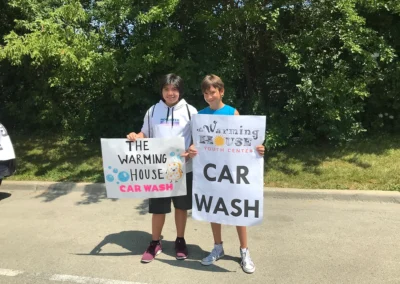Photo of kids holding up signs for a car wash.